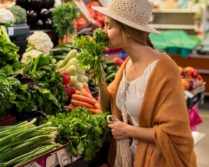 Woman-At-Market-Smelling-Fresh-Herbs