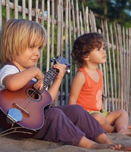 Two_Children_On_The_Beach_One_Playing_Ukulele